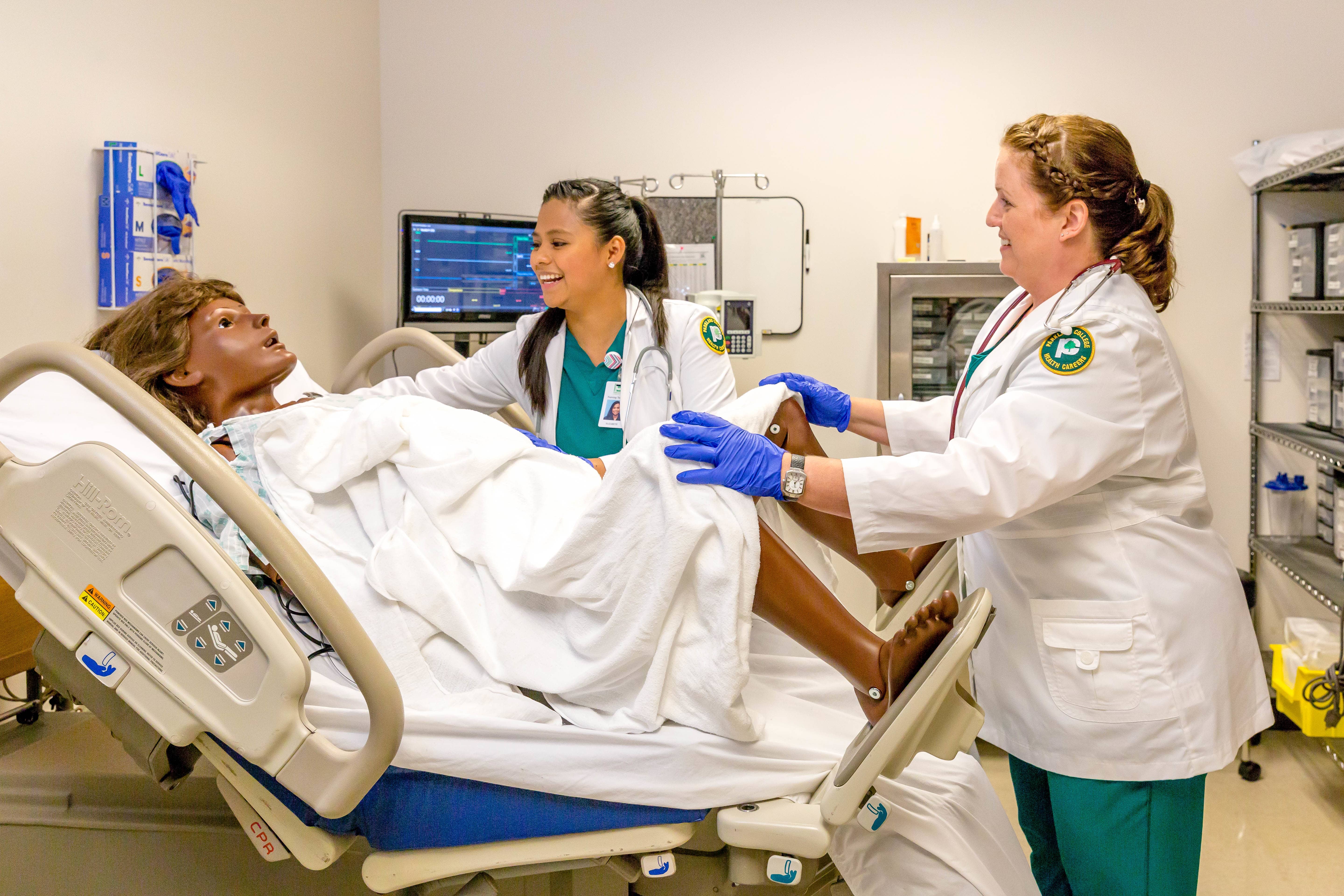 nursing students practicing with mannequin